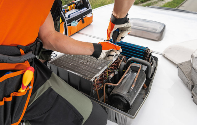 a man in an orange vest working on a car engine a man in an orange vest working on a car engine