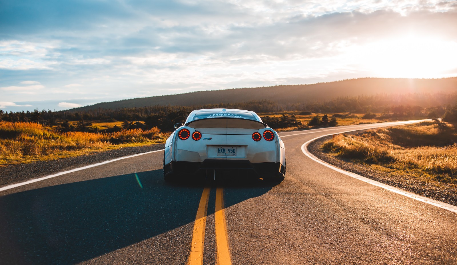 Car driving a sunset road