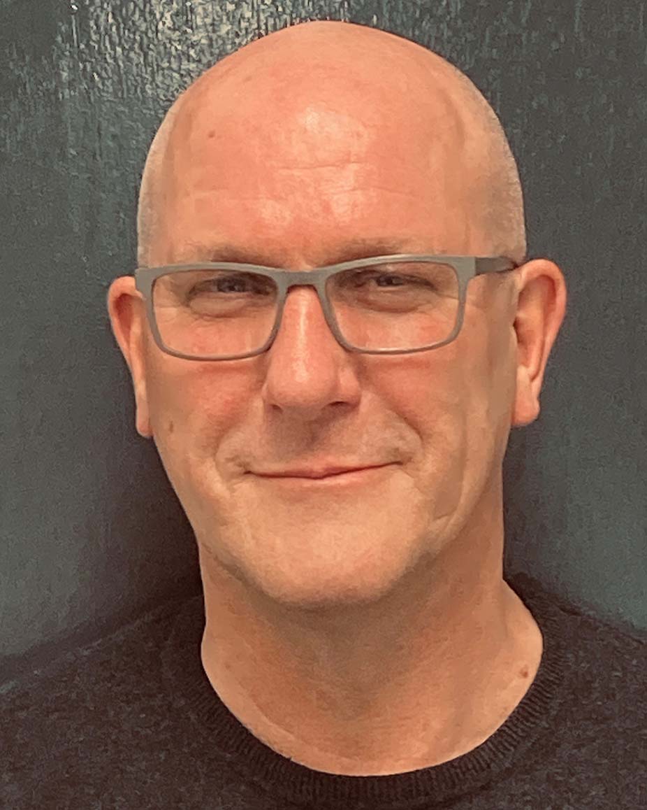 a man wearing glasses smiling