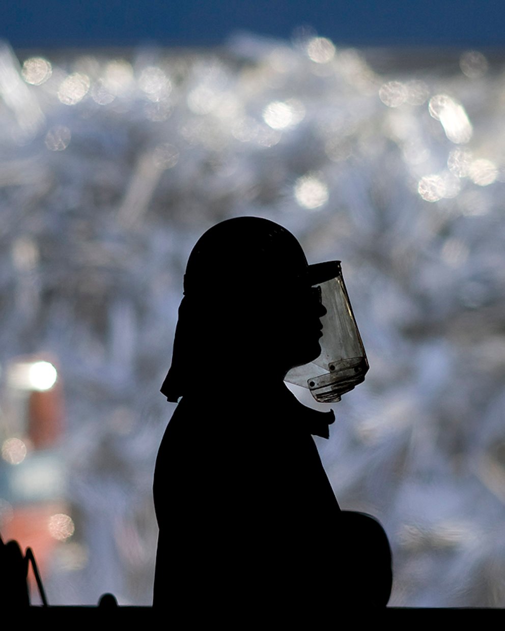 worker in front of a huge pile of aluminium