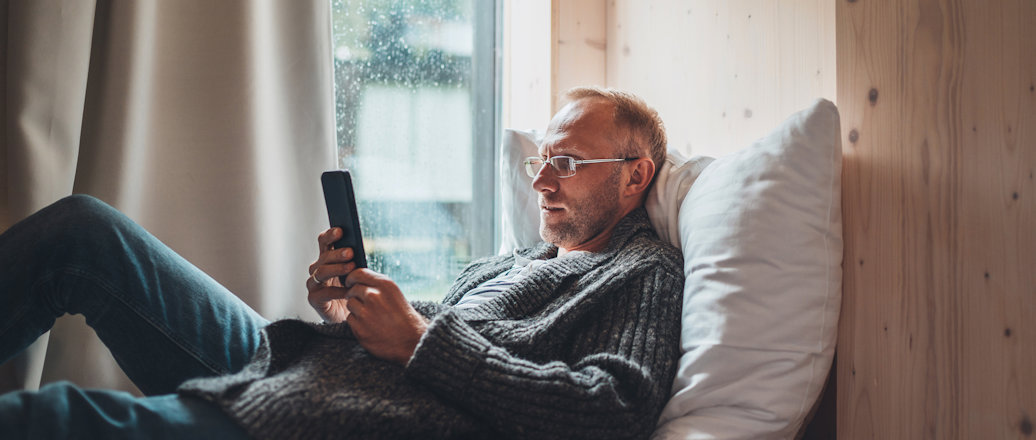 a man sitting on a couch holding a phone