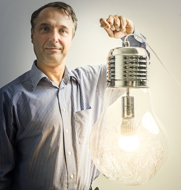 Man holding a large transparent bulb filled with led strings