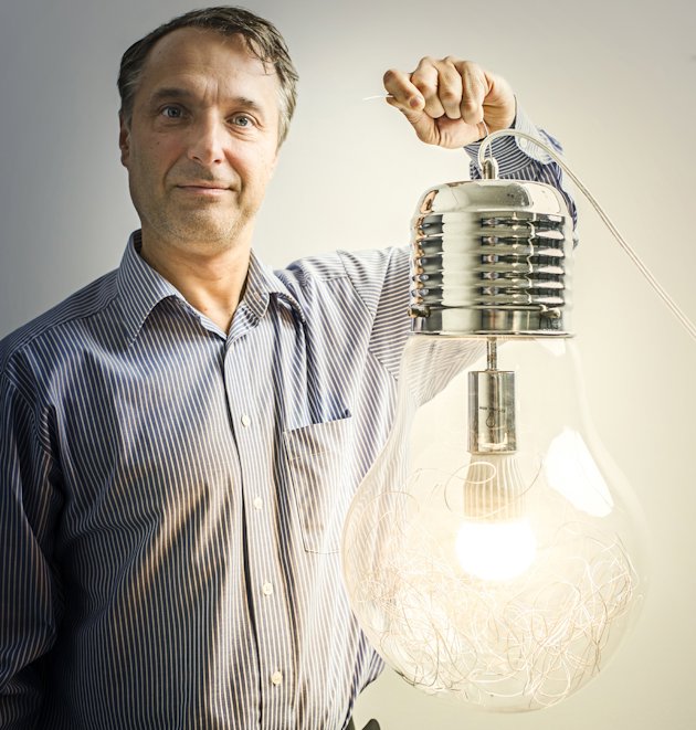 Man holding a large transparent bulb filled with led strings