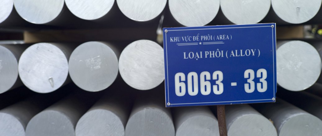 Stacks of aluminium rods, with a vietnamese sign.