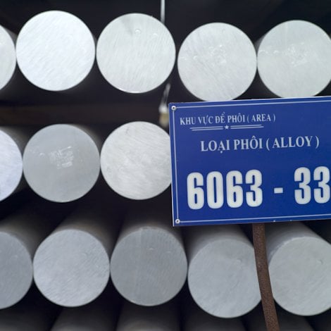 Stacks of aluminium rods, with a vietnamese sign.