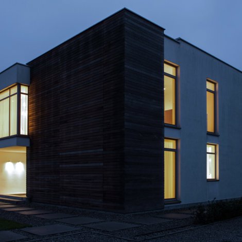 Night exterior of a house with warm light from windows