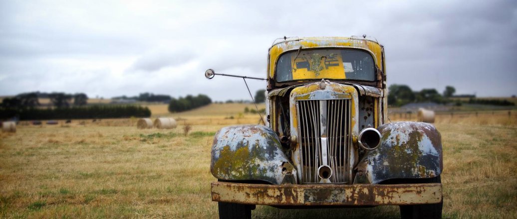 old rusted car in a field
