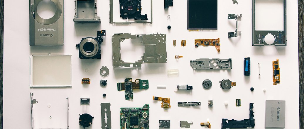 A disassembled pocket camera that shows the complexity of designing for disassembly