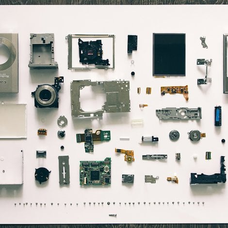 A disassembled pocket camera that shows the complexity of designing for disassembly