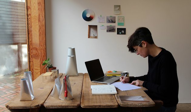 woman at table with computer and drawing materials