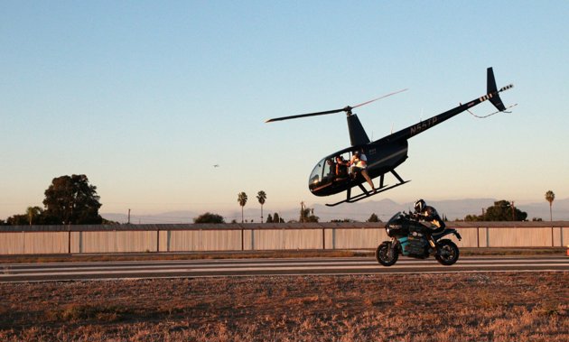 Helicopter flying low over a motor cycle